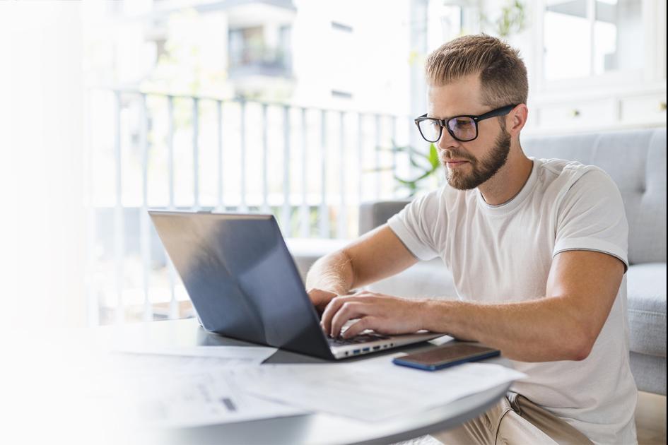 mężczyzna siedzący przy laptopie