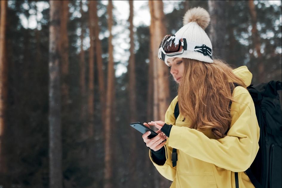 dziewczyna w żółtej kurtce patrząca na telefon