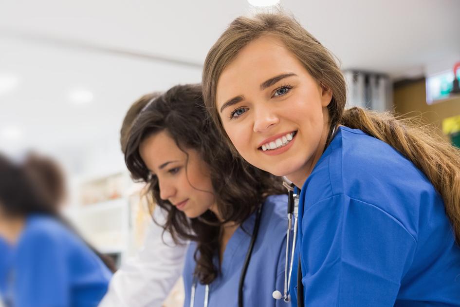 młoda lekarka uśmiechająca się i patrząca w stronę obiektywu